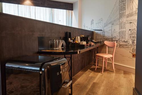 a kitchen with a counter and a table and a stool at voco Manchester - City Centre by IHG in Manchester