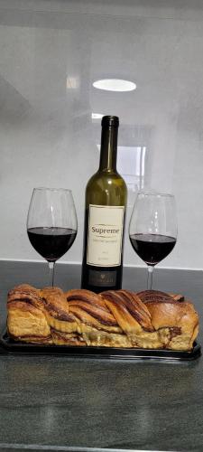 two glasses of wine next to a plate of bread at חלון לים - דירת נופש באכזיב in Nahariyya