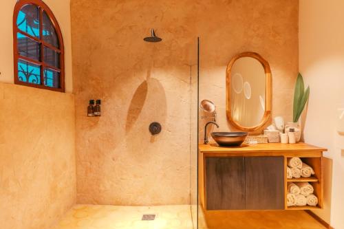 a bathroom with a shower with a sink and a mirror at awā San José in San José