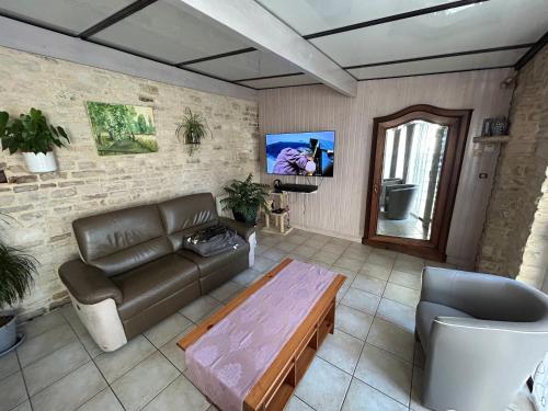 un salon avec un canapé et une table basse dans l'établissement Maison dans village cotier, à La Celle-sous-Gouzon