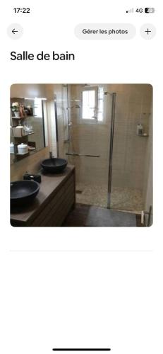 une salle de bain avec deux lavabos et une douche en verre dans l'établissement Maison dans village cotier, à La Celle-sous-Gouzon