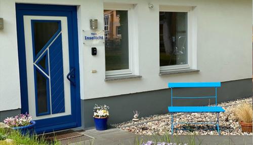 a blue bench sitting outside of a house with a door at Insellicht BRINKMANNHAUS - entspannend groß fast am Strand Sauna Terrasse Grill in Bansin