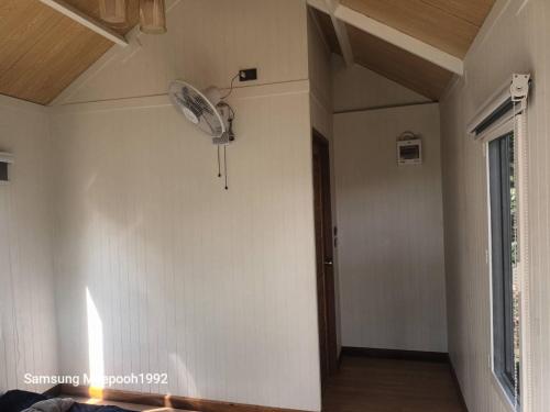 an empty room with a fan on the wall at PhaluayCamping in Koh Phaluai
