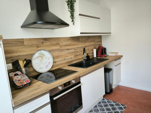 une cuisine avec des armoires blanches et un évier dans l'établissement Gîte Champagne Philippe Moutardier - Chambre Arôme, à Chézy-sur-Marne