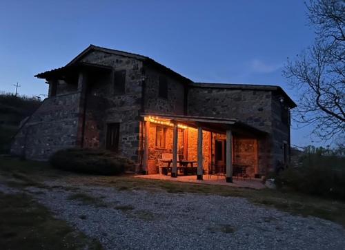 an old stone house with the lights on at Casale meraviglioso Val d'Orcia con piscina in Radicofani