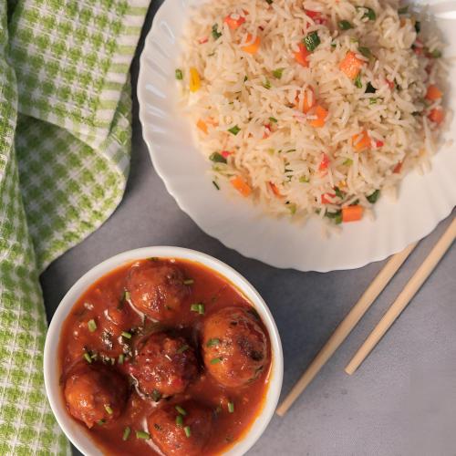 a bowl of meatballs and rice next to a plate of food at Hotel City Palace in Varanasi