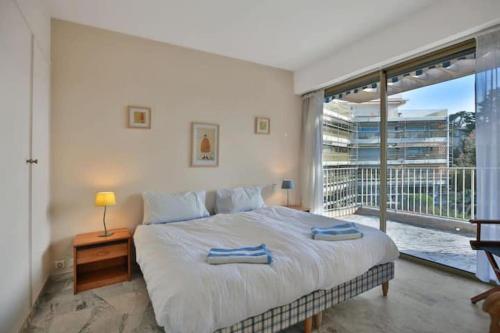 une chambre avec un grand lit et une grande fenêtre dans l'établissement 3BDR with SeaViews and Big Terrace, à Antibes