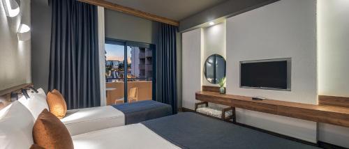 una camera d'albergo con un letto e una televisione di Kaia Coracesium a Alanya