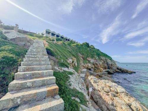 a set of stone steps next to the ocean at Hotel Recanto do Atalaia in Arraial do Cabo