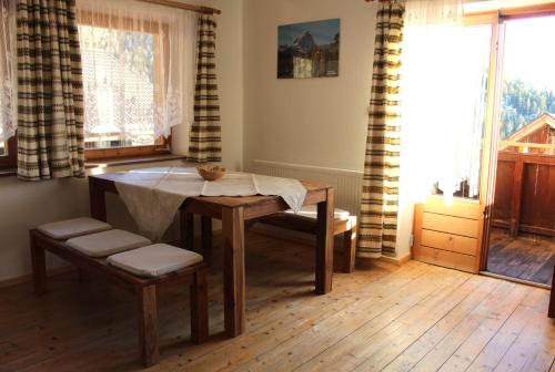 a dining room with a table and chairs and a window at Lü de Terza in San Vigilio Di Marebbe