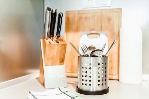a container of utensils on a counter next to a knife block at Apartmán Gustav Klimt in Český Krumlov