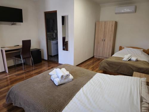a hotel room with two beds and a desk at Pensiunea Hanul Huniazilor HD in Hunedoara