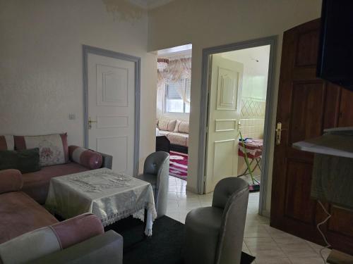 a living room with a couch and a table and chairs at Appartement meublé in Meknès