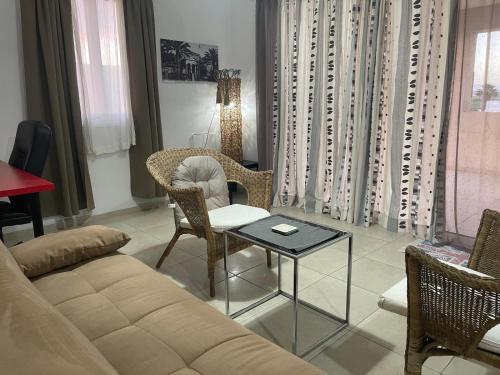 a living room with a couch and chairs and a table at Sunset Windmill Hideaway in Tersephanou