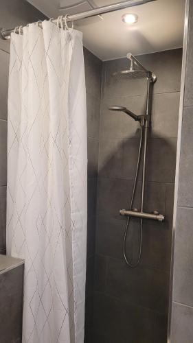 a shower with a white shower curtain in a bathroom at TinyWohnung im Pott in Castrop-Rauxel