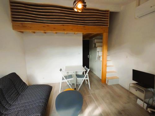 un salon avec un lit, une table et un canapé dans l'établissement Logement à deux pas du lac Carcans Maubuisson, à Carcans