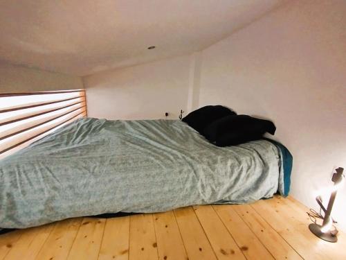 Ce lit se trouve dans une chambre dotée de parquet. dans l'établissement Logement à deux pas du lac Carcans Maubuisson, à Carcans