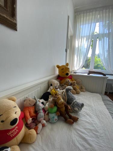 a bunch of stuffed animals sitting on a bed at Walden in Lo-Reninge
