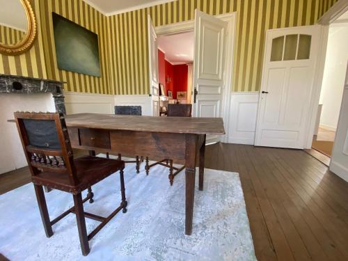 a dining room with a wooden table and a chair at Walden in Lo-Reninge
