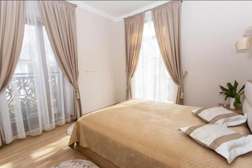 a bedroom with a large bed in front of windows at New two bedroomJurmala apartment in Jūrmala