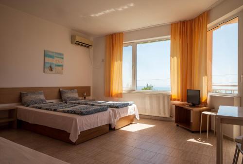 a bedroom with a bed and a large window at Family Hotel Perla in Golden Sands