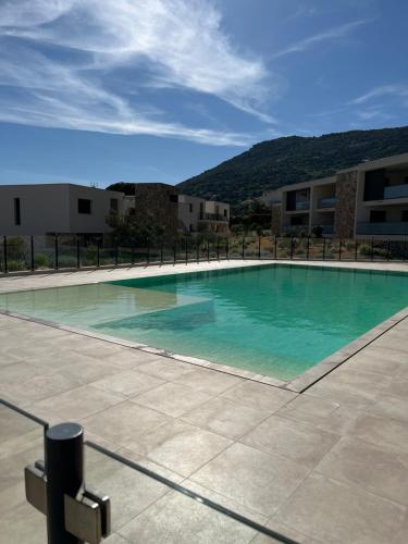 une grande piscine devant un immeuble dans l'établissement T2 CALVI, à Calvi