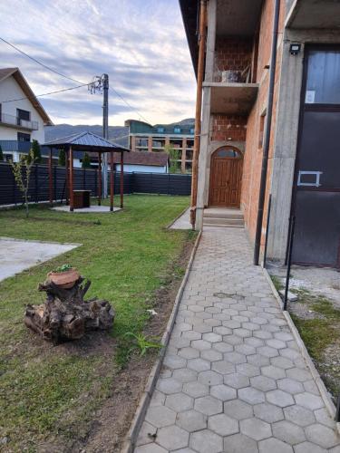 a sidewalk next to a building with a tree stump at DM home in Bajina Bašta