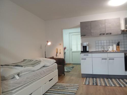 a bedroom with a bed and a kitchen at Komplette schöne Wohnung In Seenähe Attersee und Traunsee Oberösterreich direkte Buchung möglich keine Freigabe erforderlich Raumüberlassung siehe Inserat 50 Eur Kaution bereits in Buchungsbetrag enthalten! in Attnang-Puchheim