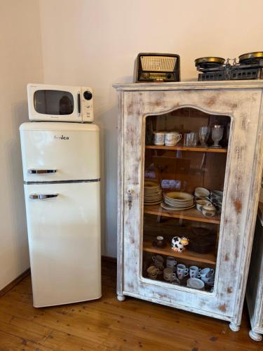 an old cabinet with a microwave on top of it next to a refrigerator at Domek u Dandy in Ludvíkov