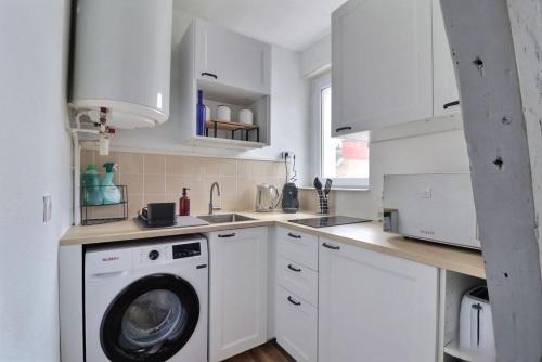 une cuisine avec des armoires blanches et une machine à laver dans l'établissement Charmant studio à Vannes, à Vannes