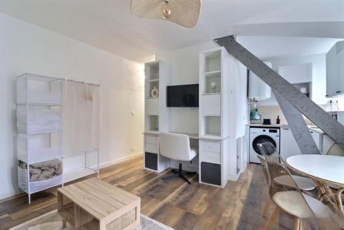 une pièce blanche avec une table et un bureau et une table et des chaises dans l'établissement Charmant studio à Vannes, à Vannes