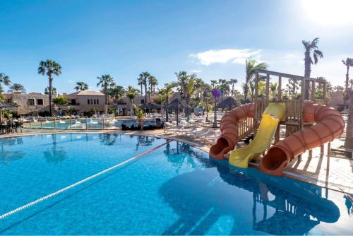 een zwembad met een glijbaan in een resort bij Playa y Palmera in Corralejo