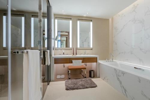 a bathroom with a tub and a sink and a shower at The Address Residences Dubai Opera - Luxury 3BR Stay with Stunning Burj Khalifa & Fountain Views in Dubai