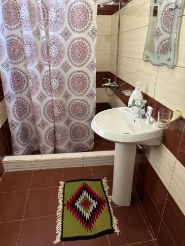 a bathroom with a sink and a shower curtain at Among cherries & Village in Salari