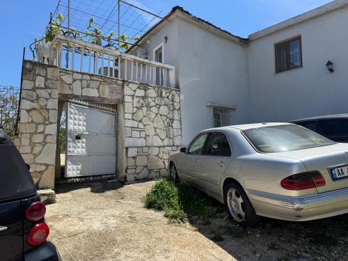 a car parked in front of a white house at Among cherries & Village in Salari