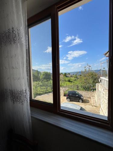 a window with a view of a car in a driveway at Among cherries & Village in Salari
