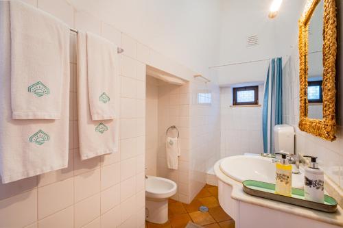 un bagno con lavandino, WC e asciugamani di Quinta da Bisa - Casa das Pedrinhas ad Algoz