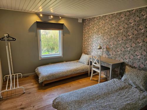 ein Schlafzimmer mit zwei Betten und einem Fenster in der Unterkunft Sea Breeze Cottage in Färjestaden