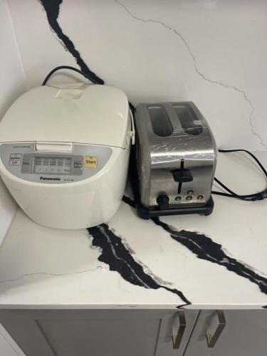 a toaster and a toaster sitting on a shelf at Cozy four bedroom House in Vancouver West in Vancouver