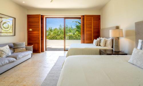 a hotel room with two beds and a couch at Terrazas, Treetop Hideaway with Golf Views in Punta Mita