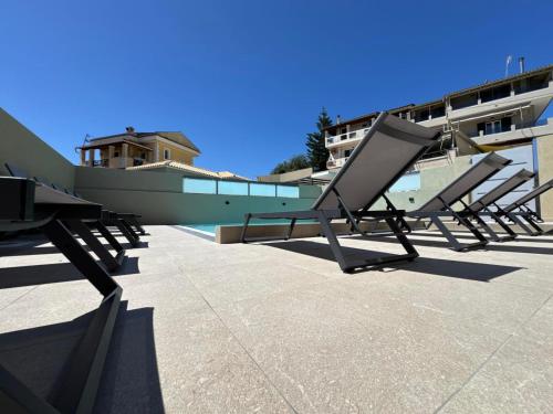 a row of chairs sitting on a patio next to a building at Alex Apartment Suites in Virós