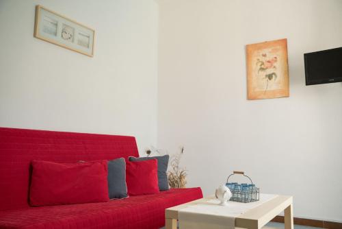 a red couch in a living room with a table at Blumarine Residence Club in Ostuni