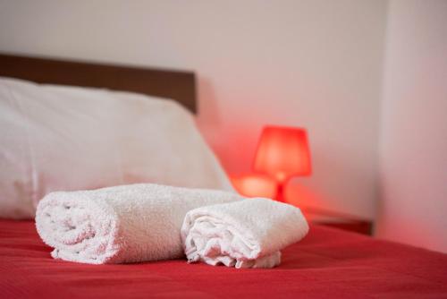 a white towel laying on top of a bed at Blumarine Residence Club in Ostuni