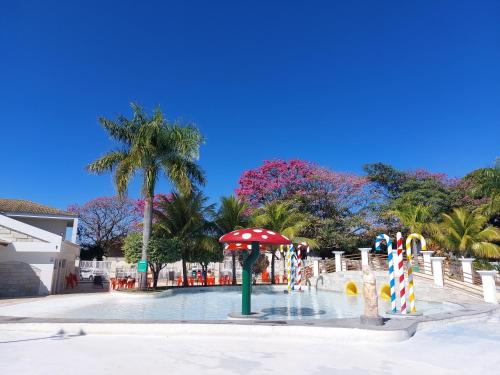 a pool with an umbrella and a water park at Lacqua diRoma 1 - Apartamentos JN in Caldas Novas