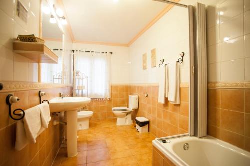 y baño con lavabo, aseo y bañera. en Hostal Castilla, en Aranjuez