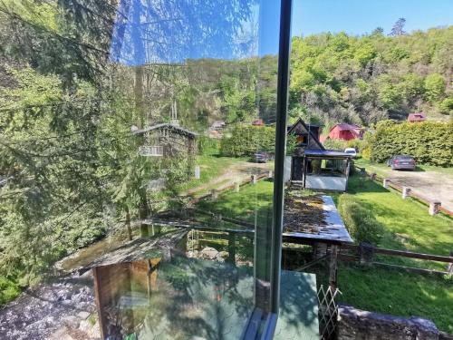 a view from a glass window of a house at fairy tale cottage on water stream, 30 minutes from South Prague in Davle