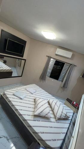 a large bed in a room with a window at Hotel rebeka in São Paulo