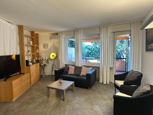 a living room with two couches and a tv at Apartment direkt am Luganersee in Bissone