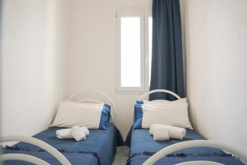 a room with two beds with blue and white pillows at Blumarine Residence Club in Ostuni