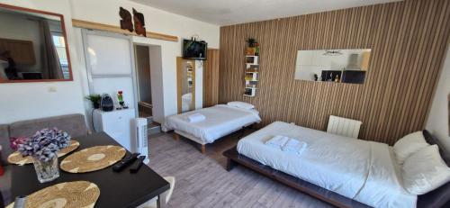 Cette chambre comprend un lit et une table avec un canapé. dans l'établissement Studio Cosy à 5 minutes de Rennes - 3 personnes, à Noyal-Châtillon-sur-Seich